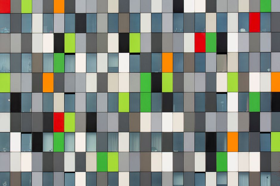 Vibrant geometric facade of a modern building showcasing colorful panels and windows.