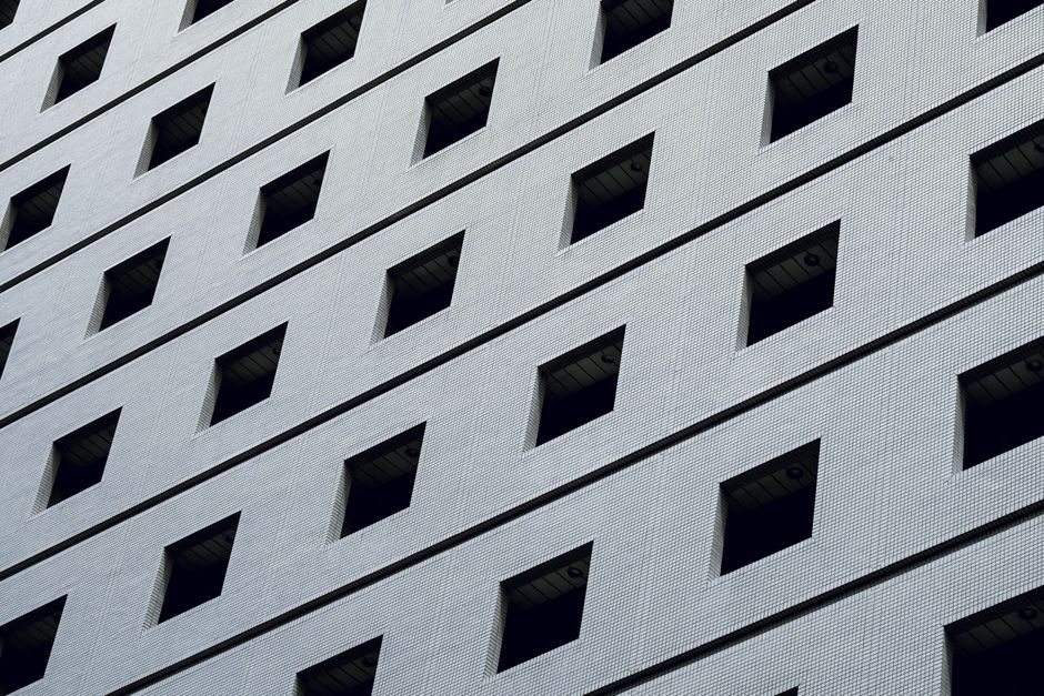 A low angle view showcasing a modern building facade with geometric patterns and symmetrical windows.