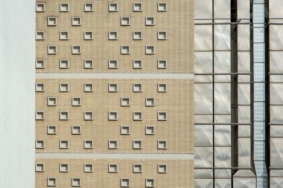 Close-up shot of a building facade with repeating square patterns and metallic elements.
